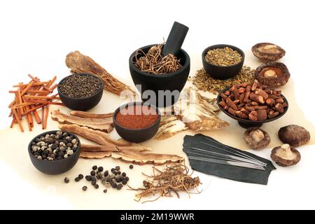 Chinesische Akupunkturnadeln mit Kräutern und Gewürzen in pflanzlichen Heilmitteln. Naturorientalisches Versorgungskonzept. Auf Pergamentpapier. Stockfoto