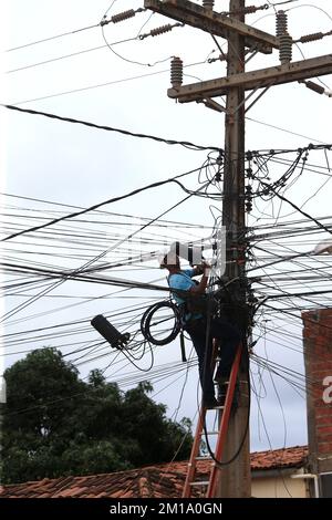 salvador, bahia, brasilien - 8. dezember 2022: Arbeiter führt Reparaturen an Glasfaserkabeln neben der Verkabelung des elektrischen Netzwerkpols in der Stadt durch Stockfoto