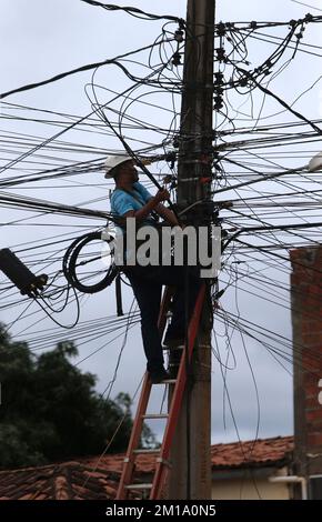 salvador, bahia, brasilien - 8. dezember 2022: Arbeiter führt Reparaturen an Glasfaserkabeln neben der Verkabelung des elektrischen Netzwerkpols in der Stadt durch Stockfoto