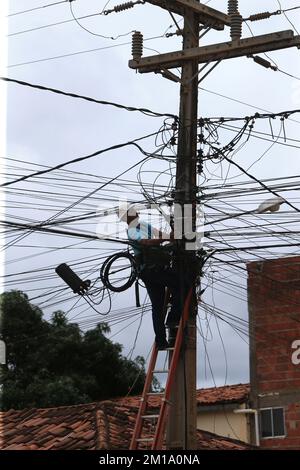 salvador, bahia, brasilien - 8. dezember 2022: Arbeiter führt Reparaturen an Glasfaserkabeln neben der Verkabelung des elektrischen Netzwerkpols in der Stadt durch Stockfoto