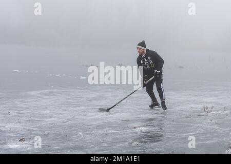 Bluntisham, Cambridgeshire, Großbritannien. 11.. Dezember 2022. Die Leute machen das Beste aus dem eiskalten Wetter auf den gefrorenen Fennebeln. Nach mehreren Tagen mit Temperaturen unter Null hat das Winterwetter das flache Fenlandwasser gefrieren lassen, um im Freien Fenschlittschuhlaufen zu können. Der Kaltstart wird voraussichtlich bis in die nächste Woche andauern. Kredit: Julian Eales/Alamy Live News Stockfoto