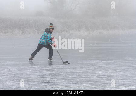 Bluntisham, Cambridgeshire, Großbritannien. 11.. Dezember 2022. Die Leute machen das Beste aus dem eiskalten Wetter auf den gefrorenen Fennebeln. Nach mehreren Tagen mit Temperaturen unter Null hat das Winterwetter das flache Fenlandwasser gefrieren lassen, um im Freien Fenschlittschuhlaufen zu können. Der Kaltstart wird voraussichtlich bis in die nächste Woche andauern. Kredit: Julian Eales/Alamy Live News Stockfoto