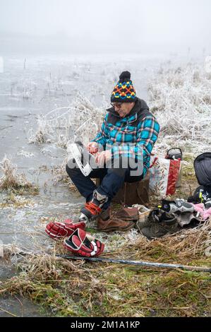 Bluntisham, Cambridgeshire, Großbritannien. 11.. Dezember 2022. Die Leute machen das Beste aus dem eiskalten Wetter auf den gefrorenen Fennebeln. Nach mehreren Tagen mit Temperaturen unter Null hat das Winterwetter das flache Fenlandwasser gefrieren lassen, um im Freien Fenschlittschuhlaufen zu können. Der Kaltstart wird voraussichtlich bis in die nächste Woche andauern. Kredit: Julian Eales/Alamy Live News Stockfoto