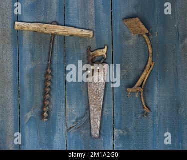 Drei primitive Handwerkzeuge hängen an der blauen Holzwand einer Schmiede-Werkstatt in Midland, South Dakota Stockfoto