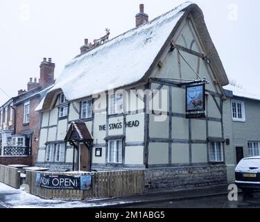 The Stag's Head, ein strohgedeckter und halbholzbedeckter Pub, der im Winter mit Schnee bedeckt ist. Stockfoto