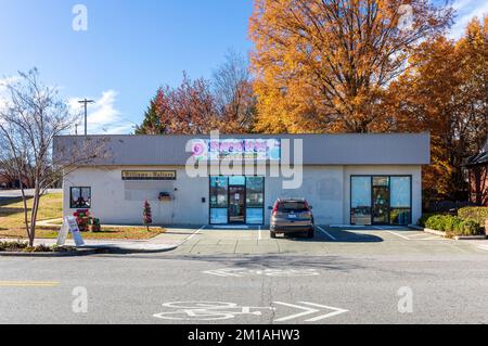 1. DEZ. 2022-WAKE FOREST, NC, USA: Sweeties Candy Shop, Gebäude und Parkplatz. Sonniger Herbsttag. Stockfoto