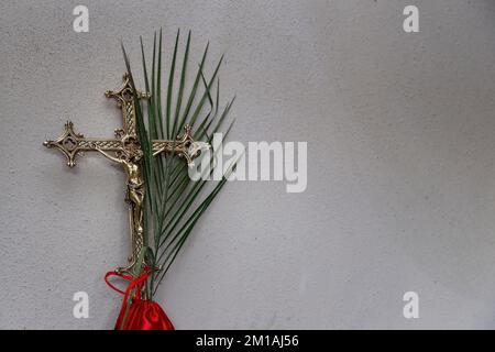 Karwoche. Prozessionskreuz und Zweige. Traditionelle katholische Feier Palmsonntag. Christlicher Glaube. Religiöses Symbol. Stockfoto