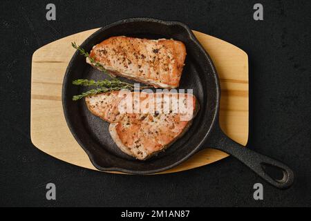 Draufsicht auf gebratenes Thunfischsteak in einer gusseisernen Pfanne Stockfoto