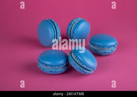 Nahaufnahme von Makronen-Kuchen in Blau auf rotem Hintergrund Stockfoto
