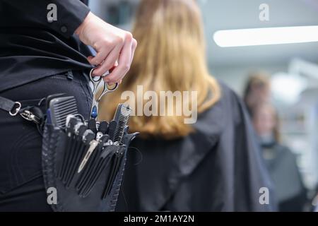 08. Dezember 2022, Sachsen-Anhalt, Wettin-Löbejün: Ein Friseur schneidet einem Kunden in einem Salon die Haare. Die 21-Jährige wird in naher Zukunft den Salon ihrer Großmutter übernehmen. Foto: Jan Woitas/dpa Stockfoto