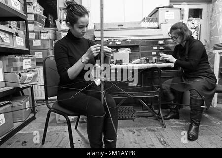 Näherinnen am Regenschirm bei James Smith & Sons. In ihrer Werkstatt, in London, England, wird ein traditioneller Regenschirm hergestellt Stockfoto