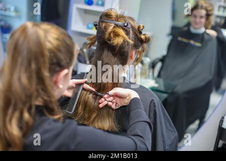 08. Dezember 2022, Sachsen-Anhalt, Wettin-Löbejün: Ein Friseur schneidet einem Kunden in einem Salon die Haare. Die 21-Jährige wird in naher Zukunft den Salon ihrer Großmutter übernehmen. Foto: Jan Woitas/dpa Stockfoto