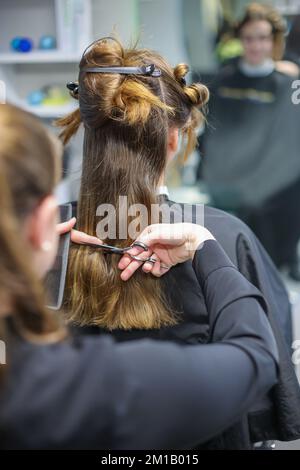 08. Dezember 2022, Sachsen-Anhalt, Wettin-Löbejün: Ein Friseur schneidet einem Kunden in einem Salon die Haare. Die 21-Jährige wird in naher Zukunft den Salon ihrer Großmutter übernehmen. Foto: Jan Woitas/dpa Stockfoto