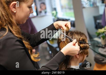 08. Dezember 2022, Sachsen-Anhalt, Wettin-Löbejün: Ein Friseur schneidet einem Kunden in einem Salon die Haare. Die 21-Jährige wird in naher Zukunft den Salon ihrer Großmutter übernehmen. Foto: Jan Woitas/dpa Stockfoto