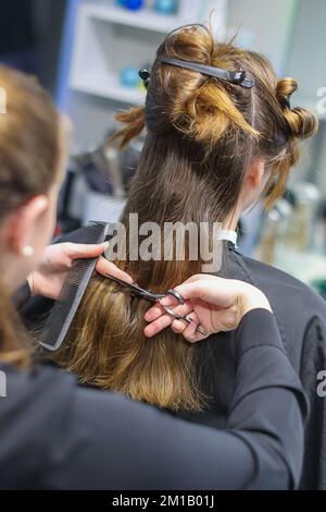 08. Dezember 2022, Sachsen-Anhalt, Wettin-Löbejün: Ein Friseur schneidet einem Kunden in einem Salon die Haare. Die 21-Jährige wird in naher Zukunft den Salon ihrer Großmutter übernehmen. Foto: Jan Woitas/dpa Stockfoto
