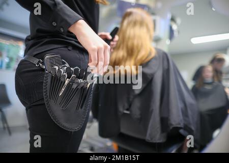 08. Dezember 2022, Sachsen-Anhalt, Wettin-Löbejün: Ein Friseur schneidet einem Kunden in einem Salon die Haare. Die 21-Jährige wird in naher Zukunft den Salon ihrer Großmutter übernehmen. Foto: Jan Woitas/dpa Stockfoto