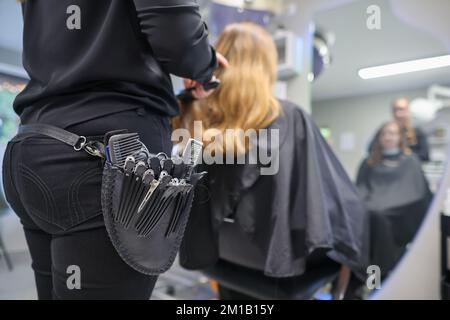 08. Dezember 2022, Sachsen-Anhalt, Wettin-Löbejün: Ein Friseur schneidet einem Kunden in einem Salon die Haare. Die 21-Jährige wird in naher Zukunft den Salon ihrer Großmutter übernehmen. Foto: Jan Woitas/dpa Stockfoto