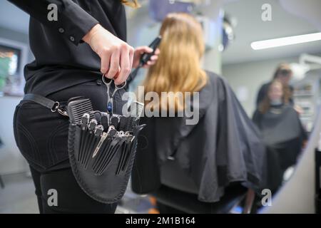 08. Dezember 2022, Sachsen-Anhalt, Wettin-Löbejün: Ein Friseur schneidet einem Kunden in einem Salon die Haare. Die 21-Jährige wird in naher Zukunft den Salon ihrer Großmutter übernehmen. Foto: Jan Woitas/dpa Stockfoto