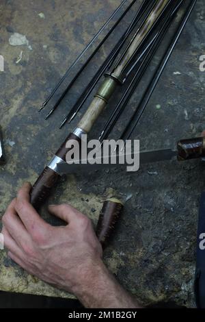 James Smith & Sons stellen in ihrer Kellerwerkstatt in London, England, einen traditionellen Regenschirm her Stockfoto