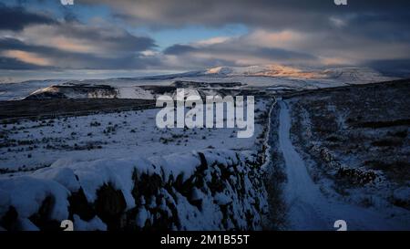 Schnee bedeckt Ackerland im Yorkshire Dales National Park bei Sonnenuntergang. Stockfoto