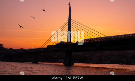 Wunderschöner Sonnenuntergang, Goldene Stunden, Golden Horn Metro Bridge und der Blick auf das Goldene Horn in Istanbul, der Sonnenuntergang, die Vögel auf dem Weg in Richtung Sonne, Stockfoto