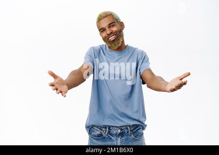 Komm her und umarme dich. Ein netter Kerl, der sich zum Kuscheln die Hände ausstreckt, begrüßt Sie, steht in lässiger Kleidung auf weißem Hintergrund Stockfoto