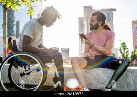 Multiethnische Typen mit Behinderung treffen sich zum ersten Mal und unterhalten sich über einen Online-Übersetzer Stockfoto