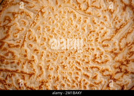 Pfannkuchen. Hintergrund. Heißer, frisch gebackener Pfannkuchen. Makrofotografie von Pfannkuchen. Nahaufnahme von Pfannkuchen. Makrofoto von Essen. Schöne Essensdecke. Stockfoto