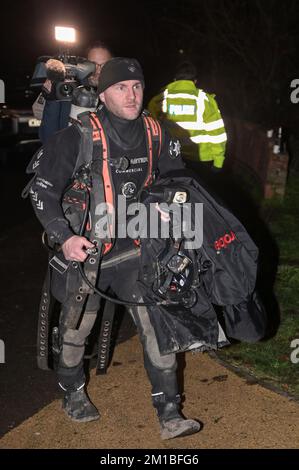 Babbs Mill Park, Solihull, 11. Dezember 2022. Taucher von der Nottinghamshire Police sind angekommen und suchen den Babbs Mill Lake nach 2 Personen, die immer noch vermisst werden, nachdem 4 andere gerettet wurden, nachdem sie am Sonntagabend durch das dünne Eis gefallen waren. Der Taucher tauchte regelmäßig mit grünem Unkraut bedeckt auf, was die schwierigen Arbeitsbedingungen veranschaulicht. Die West Midlands Police hatte früher eine Unterwasserdrohne benutzt, um die Vermissten zu lokalisieren. Feuerwehr und Krankenwagen mit spezialisierten Wasserrettungsteams sind immer noch am Einsatzort in der Nähe der Fordbridge Road, Kingshurst, Solihull England. Quelle: Stop Press Media/Alamy L Stockfoto