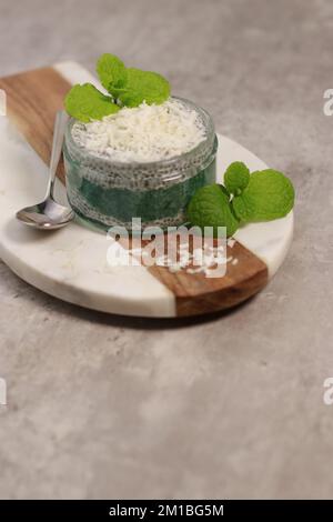 Köstlicher veganer Kokosnuss-Chia-Pudding mit Minze, auf einem weißen Tisch Stockfoto