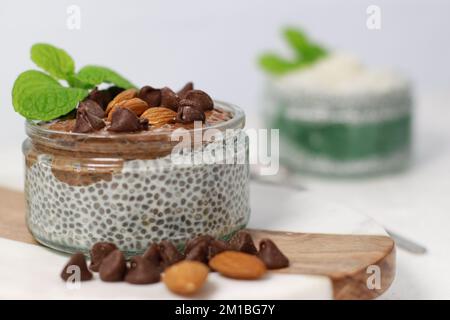 chia Pudding mit Schokolade und Mandeln auf weißem Tisch Stockfoto