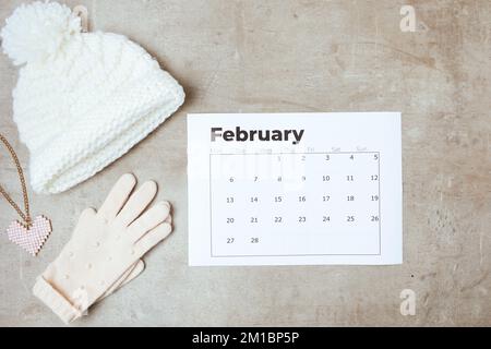 Winterdecke mit Handschuhen und februar-Kalender. Stockfoto