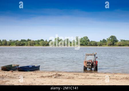 Panorama der Donau in Serbien mit Traktor am Strand während eines sonnigen Sommernachmittags in Stari Slankam, Serbien. Die Donau ist Europas seco Stockfoto