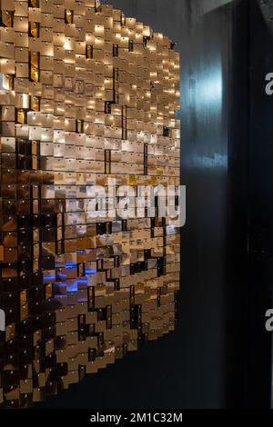 Reflexion von kleinen Kupferstücken an einer schwarzen Wand, die Menschen reflektieren, die vorbeikommen, mexiko Stockfoto