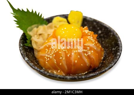 Stück japanischer Reisschüssel mit Lachs-Sashimi-Scheiben aus weich gekochten Eiern auf weißer, isolierter Schicht. Stockfoto