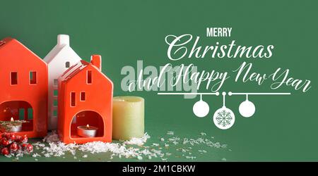 Wunderschöne Grußkarte zu Weihnachten und Neujahr mit Kerzenhaltern in Hausform auf grünem Hintergrund Stockfoto