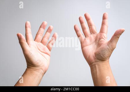 Ein Paar männliche Hände heben sich und strecken eine Geste aus. Beten, beten oder um Hilfe schreien. Stockfoto