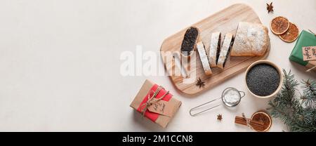 Schmackhafter Mohnstrudel und Weihnachtsgeschenke auf hellem Hintergrund mit Platz für Text Stockfoto