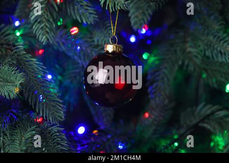 Roter Weihnachtsball auf Tannenbaum in der Nacht, Nahaufnahme Stockfoto