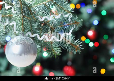 Silberner Weihnachtsball auf Tannenbaum bei Nacht, Nahaufnahme Stockfoto