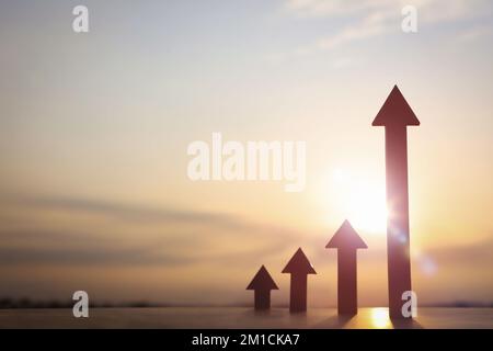 Pfeil steigt hoch und hell aufgehende Sonne Sonnenaufgang im neuen Jahr und Aktienfinanzwirtschaft Wachstum Industrie Investitionsziel Konzept Stockfoto