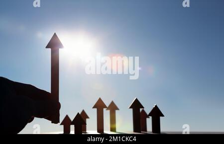 Pfeil steigt hoch und hell aufgehende Sonne Sonnenaufgang im neuen Jahr und Aktienfinanzwirtschaft Wachstum Industrie Investitionsziel Konzept Stockfoto