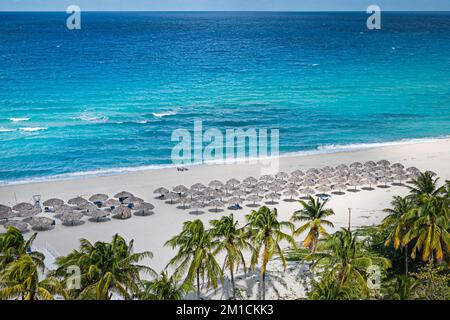 Strohschirme am Paradise Beach in der Karibik mit weißem Sand und Palmen. Drone. Drone. Stockfoto