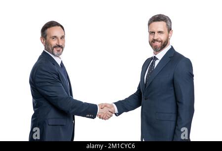 Lächelnde Geschäftsleute, die im Studio handeln. Geschäftsmänner, die mit Handschlag zu tun haben Stockfoto