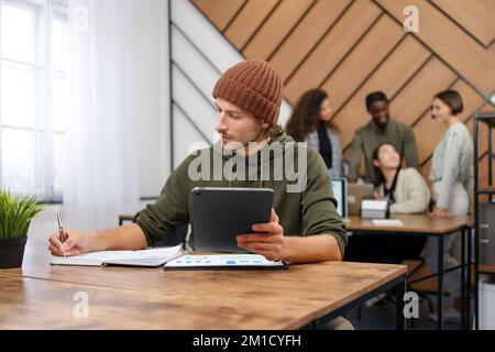 Jungunternehmer analysiert Finanzdokumente in einem Co-working Center. Stockfoto