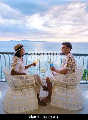 Ein paar Männer und Frauen trinken Cocktails auf dem Balkon eines Hotels in Pattaya Thailand Stockfoto