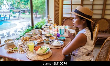 Asiatische thailändische Frauen, die ein luxuriöses Frühstück im Hotel genießen. Stockfoto