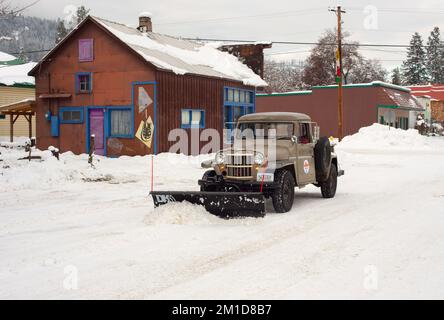 Ein 1962 Kaiser Willys Jeep-Pickup-Truck pflügt Schnee in Troja, Montana. Stockfoto