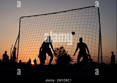 Strandfußball bei Sonnenuntergang am Katara Beach Doha Stockfoto