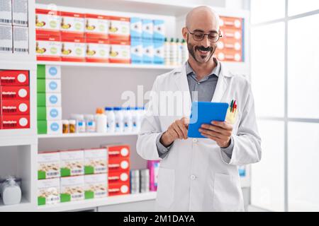 Junger hispanischer Apotheker mit Touchpad in der Apotheke Stockfoto